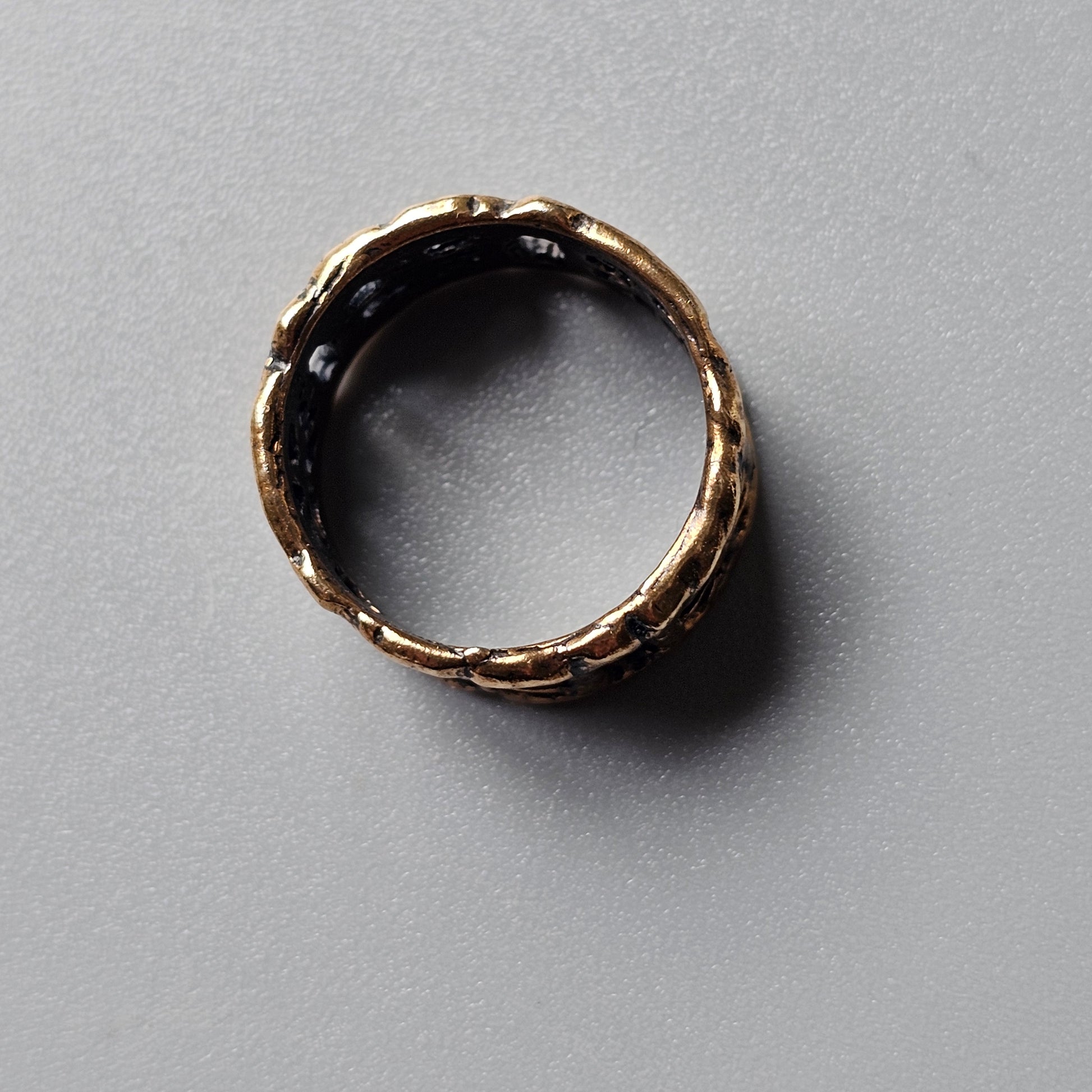 Antique-looking gold ring with a twisted or braided design.