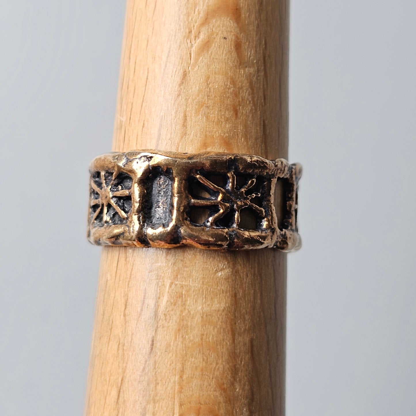 Ornate metal ring with floral or star-like designs encircling its band.