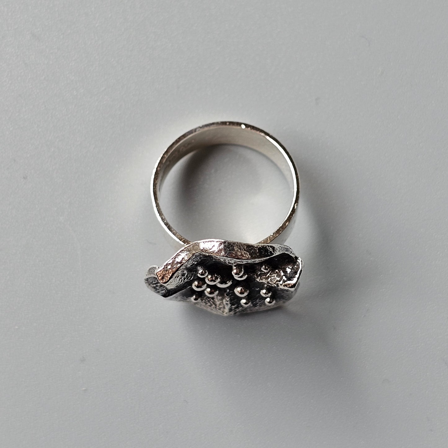 Silver ring with an intricate, textured top resembling coral or a sea-inspired design.