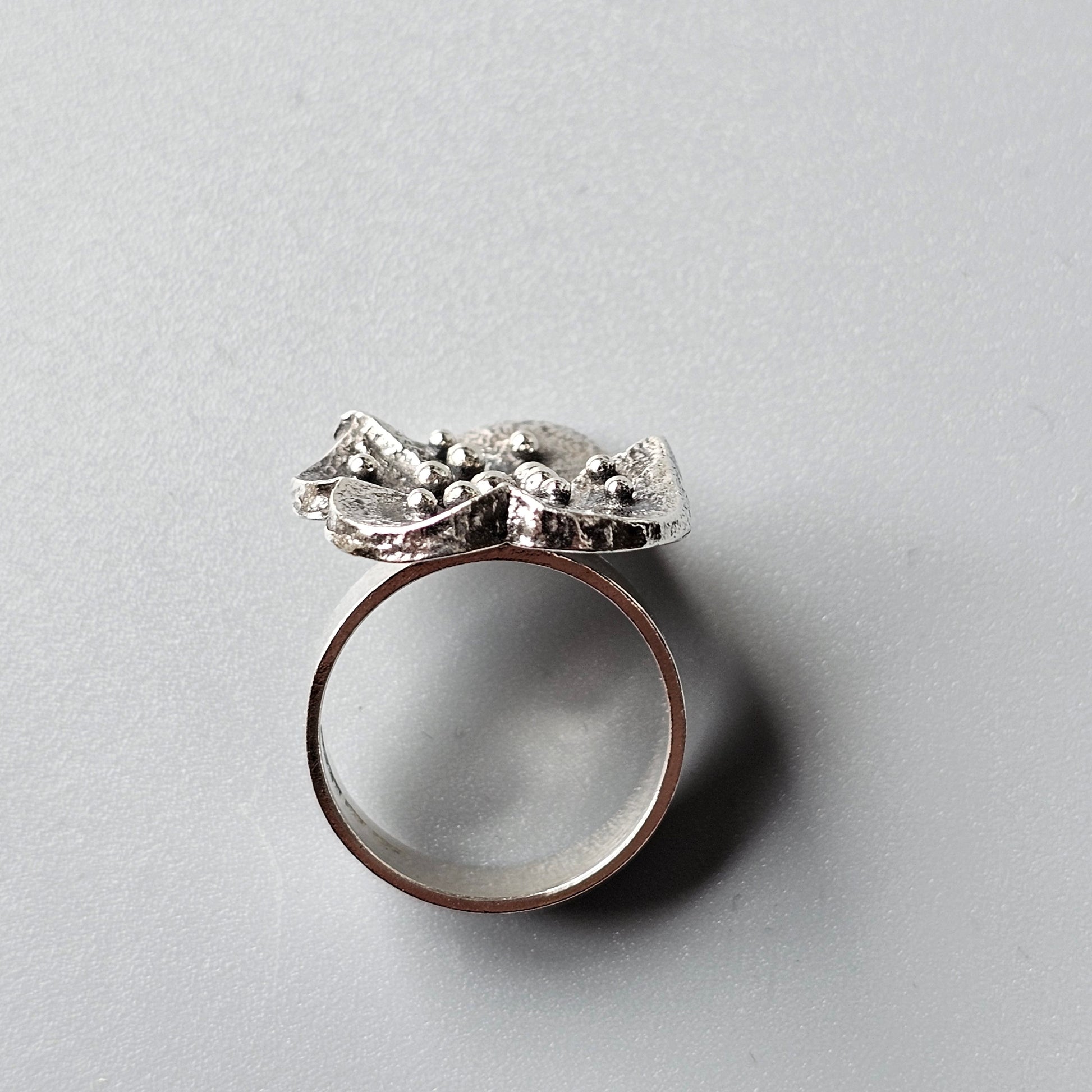 Ring with an intricate silver bow-shaped design on top.