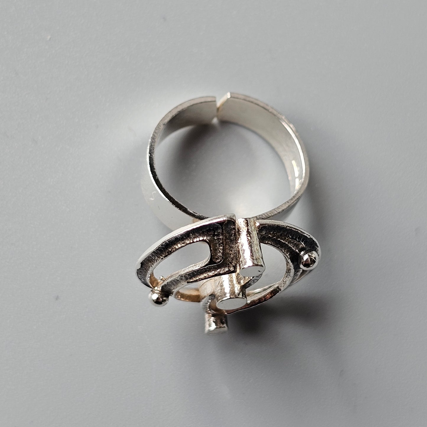 Silver ring with an abstract, sculptural design resembling interlocking shapes.