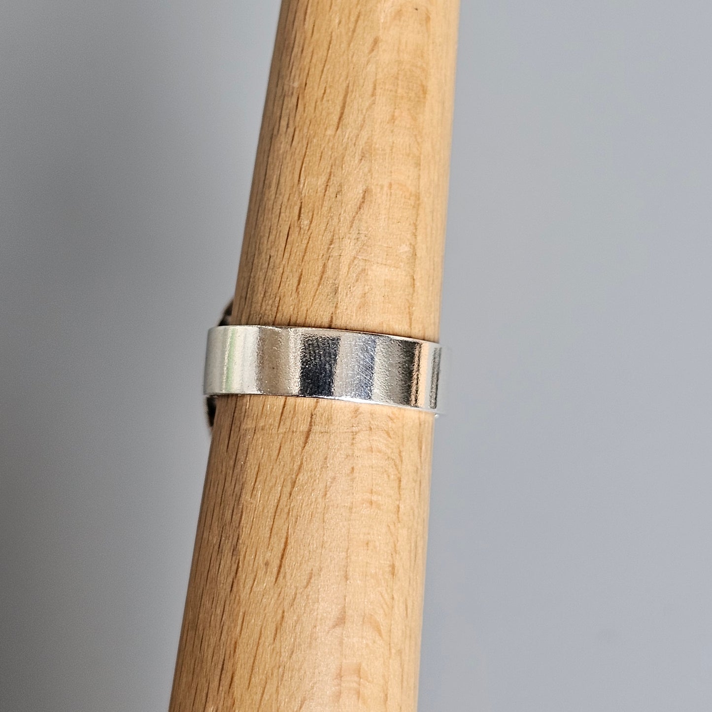 Silver ring on a wooden dowel or rod.