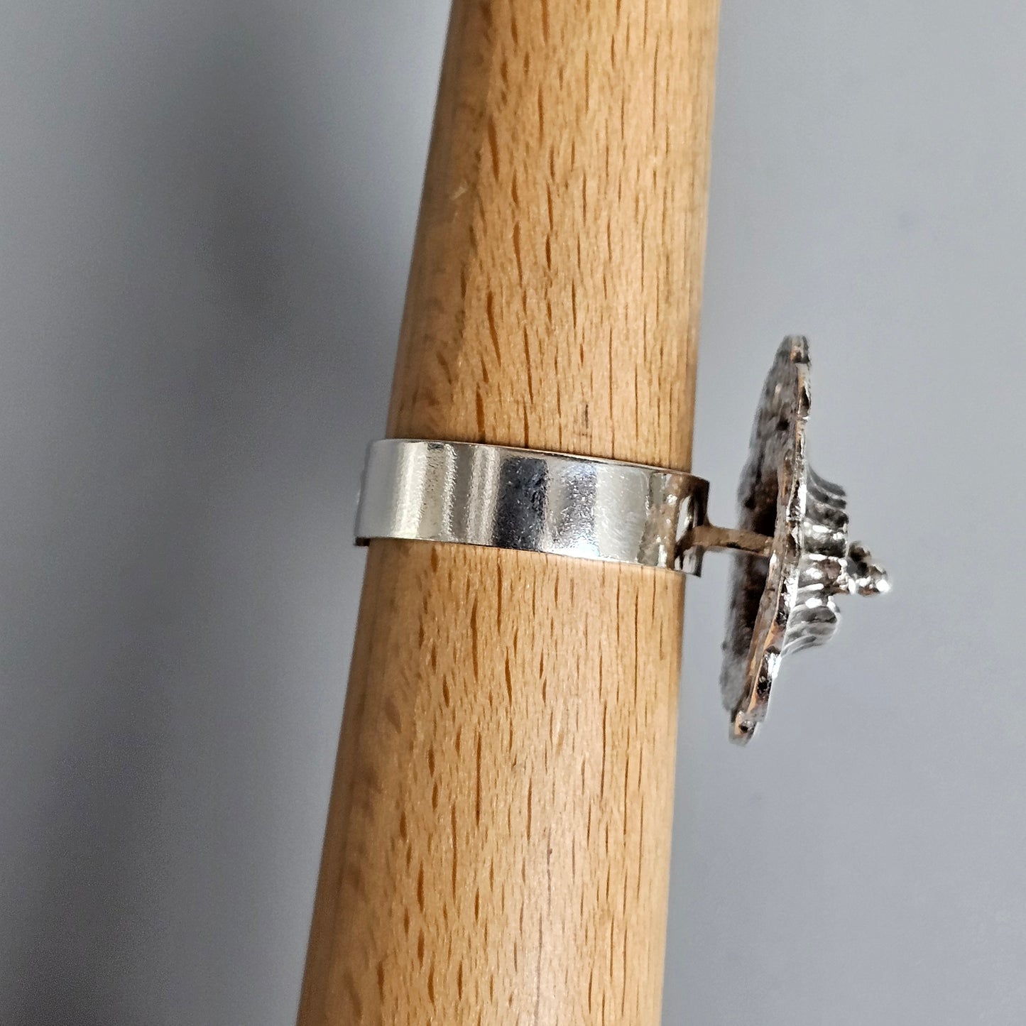 Silver ring with a snowflake-shaped design on top.