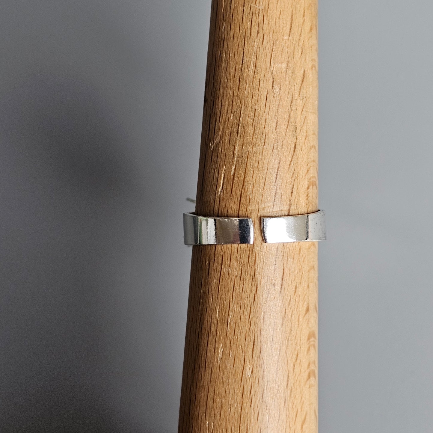 Silver ring encircling a wooden cylinder or handle.