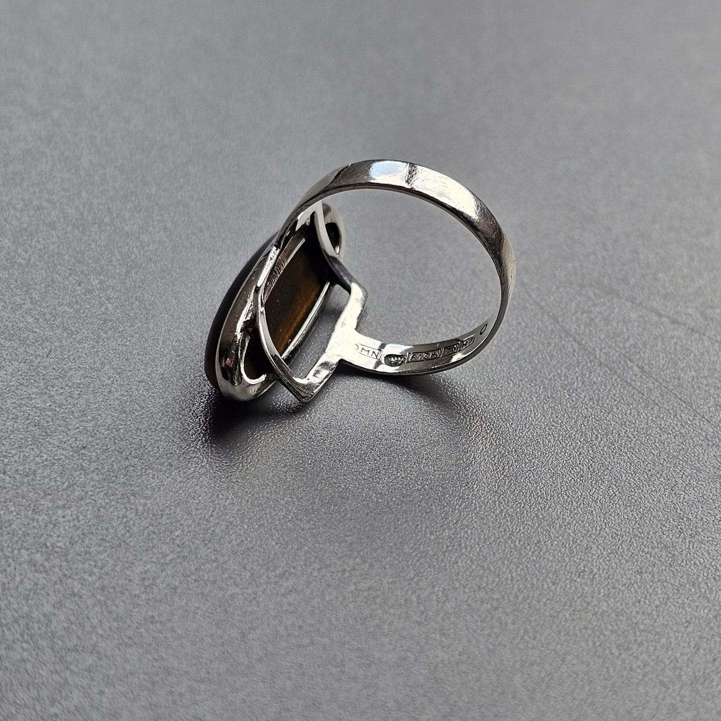 Silver ring with an abstract, open circular design on top.