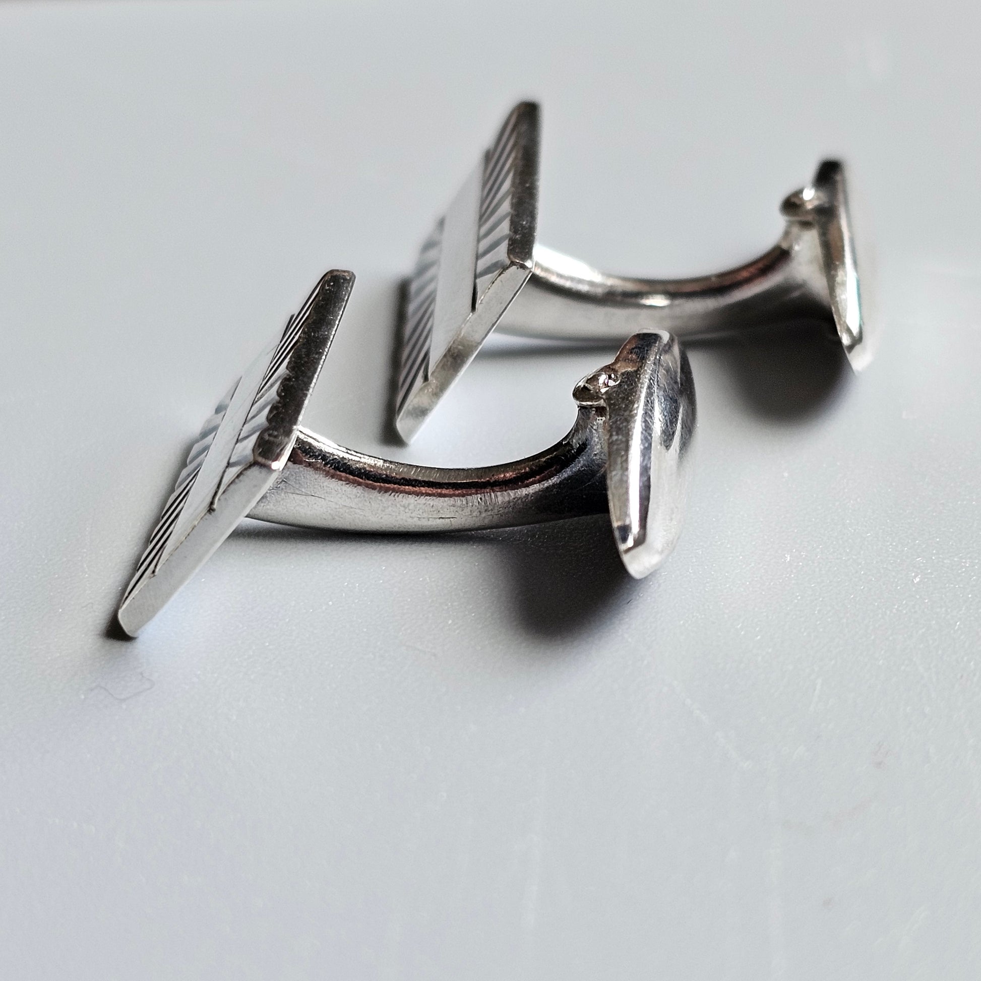 Pair of silver cufflinks with textured square faces.