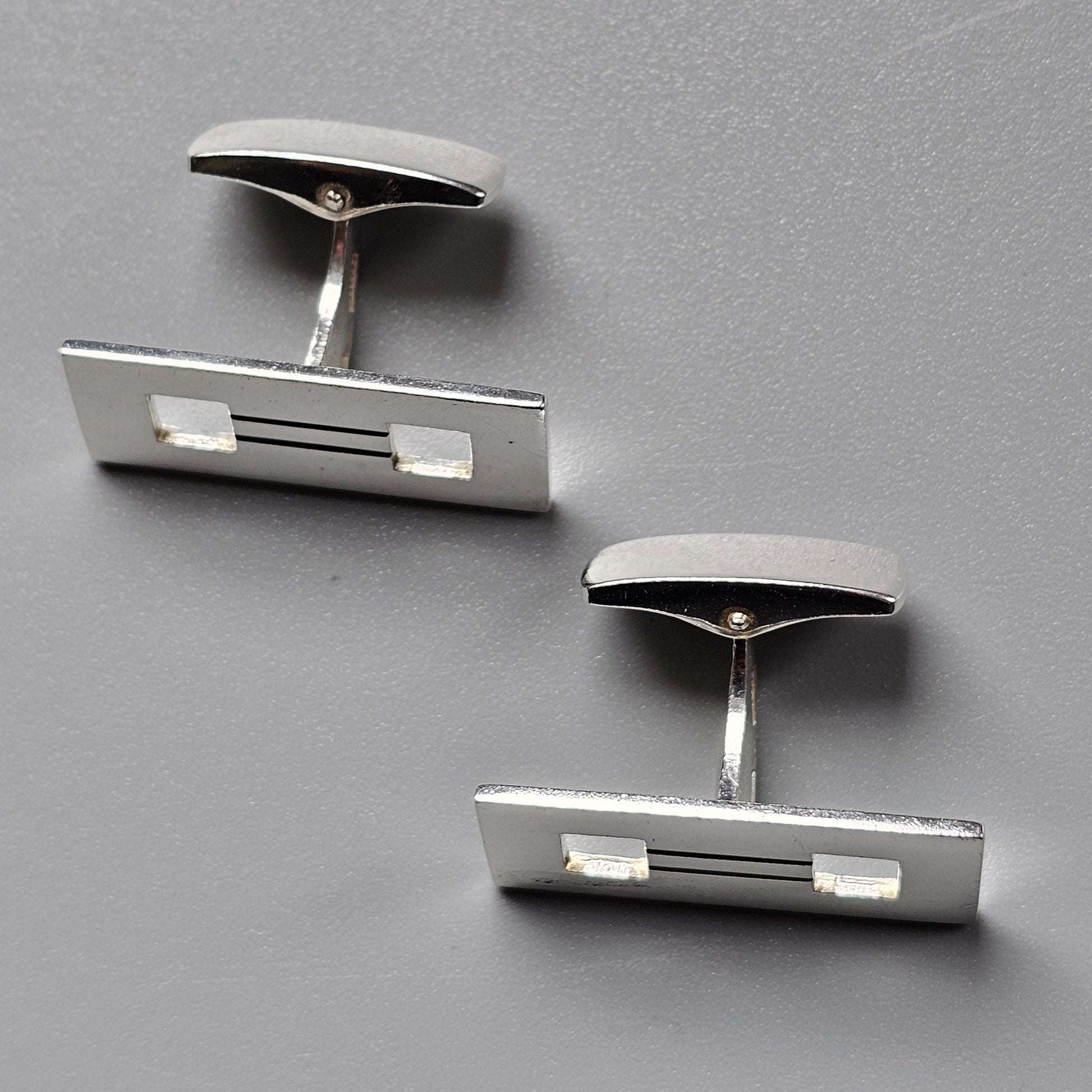 Pair of rectangular silver cufflinks with inlaid mother-of-pearl accents.