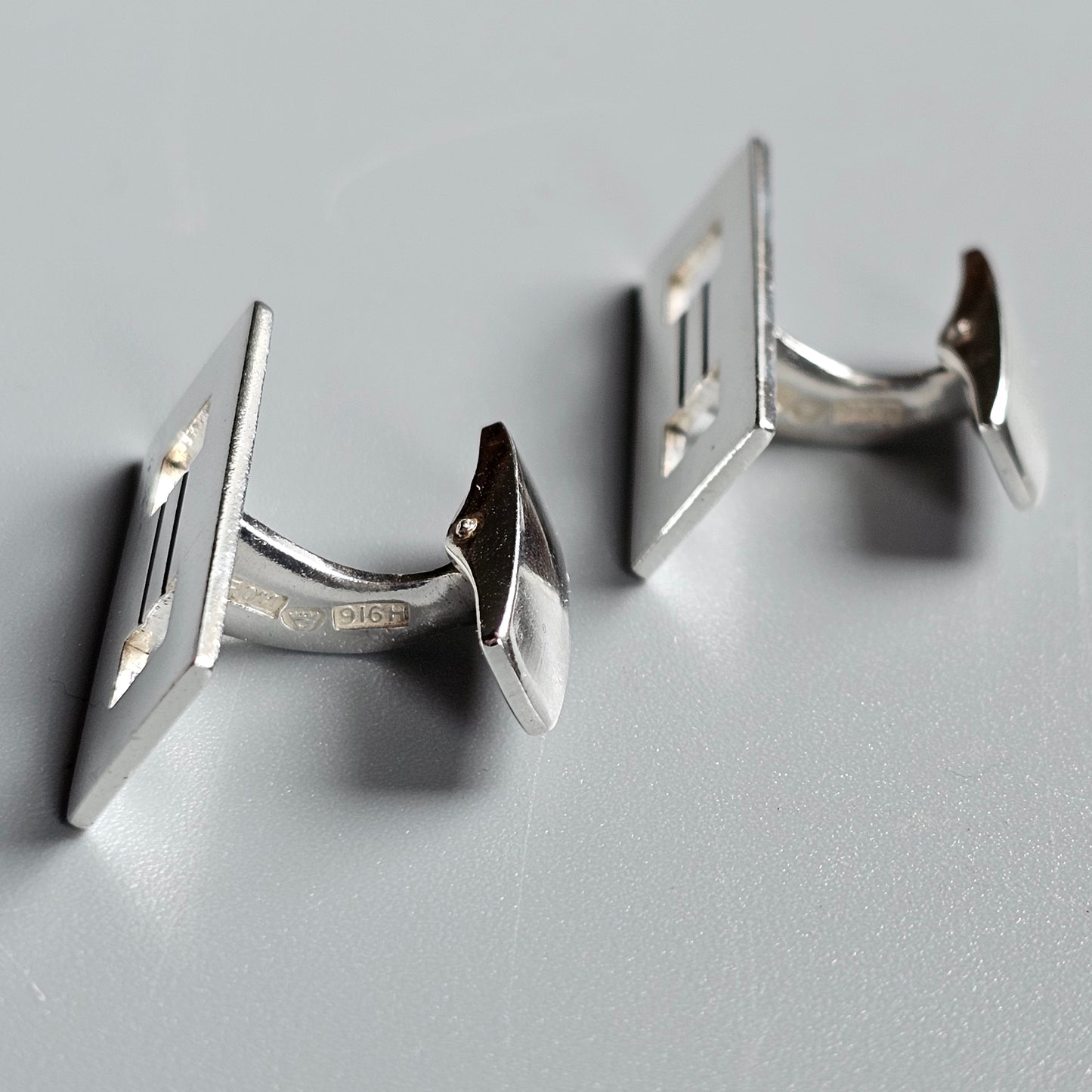 Pair of silver rectangular cufflinks with a minimalist design.