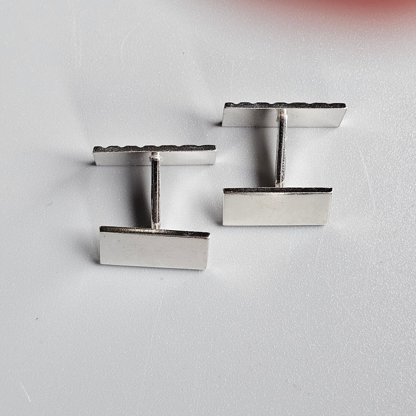 Pair of silver rectangular cufflinks with T-shaped bars.