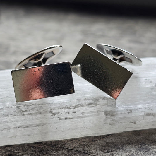 Pair of rectangular silver cufflinks with a polished metallic finish.