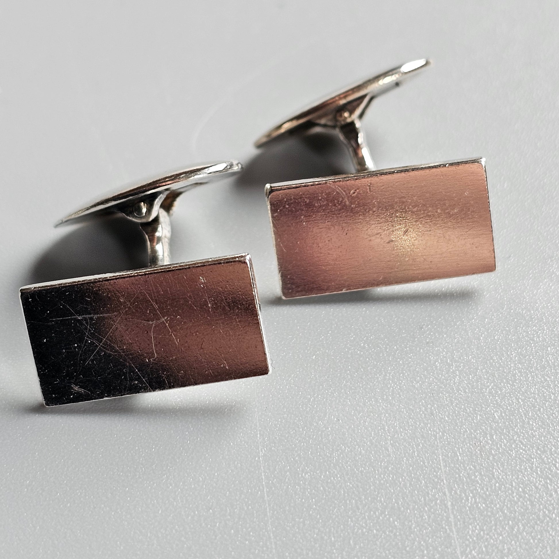 Pair of rectangular silver cufflinks with a polished metallic finish.