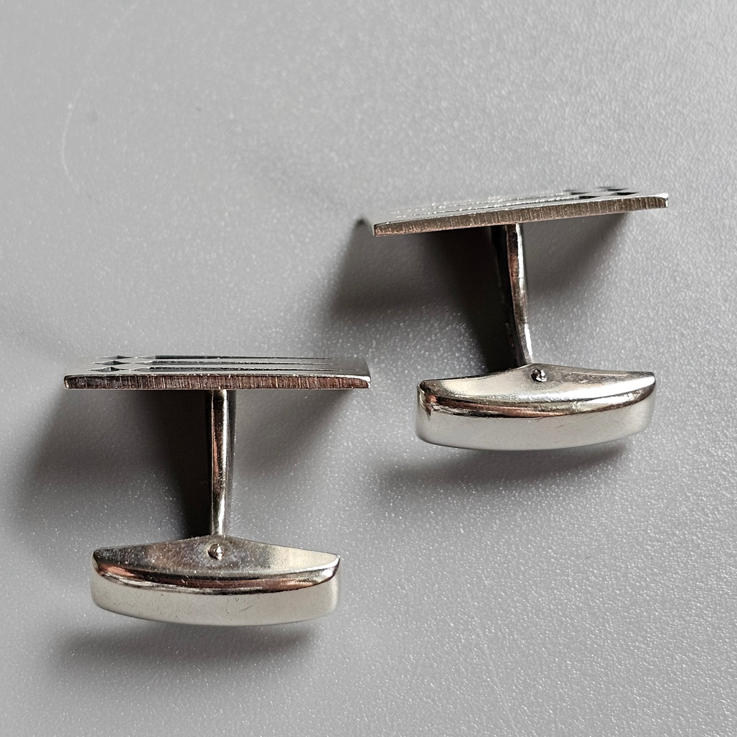 Pair of silver-toned metal cufflinks with oval-shaped bases.