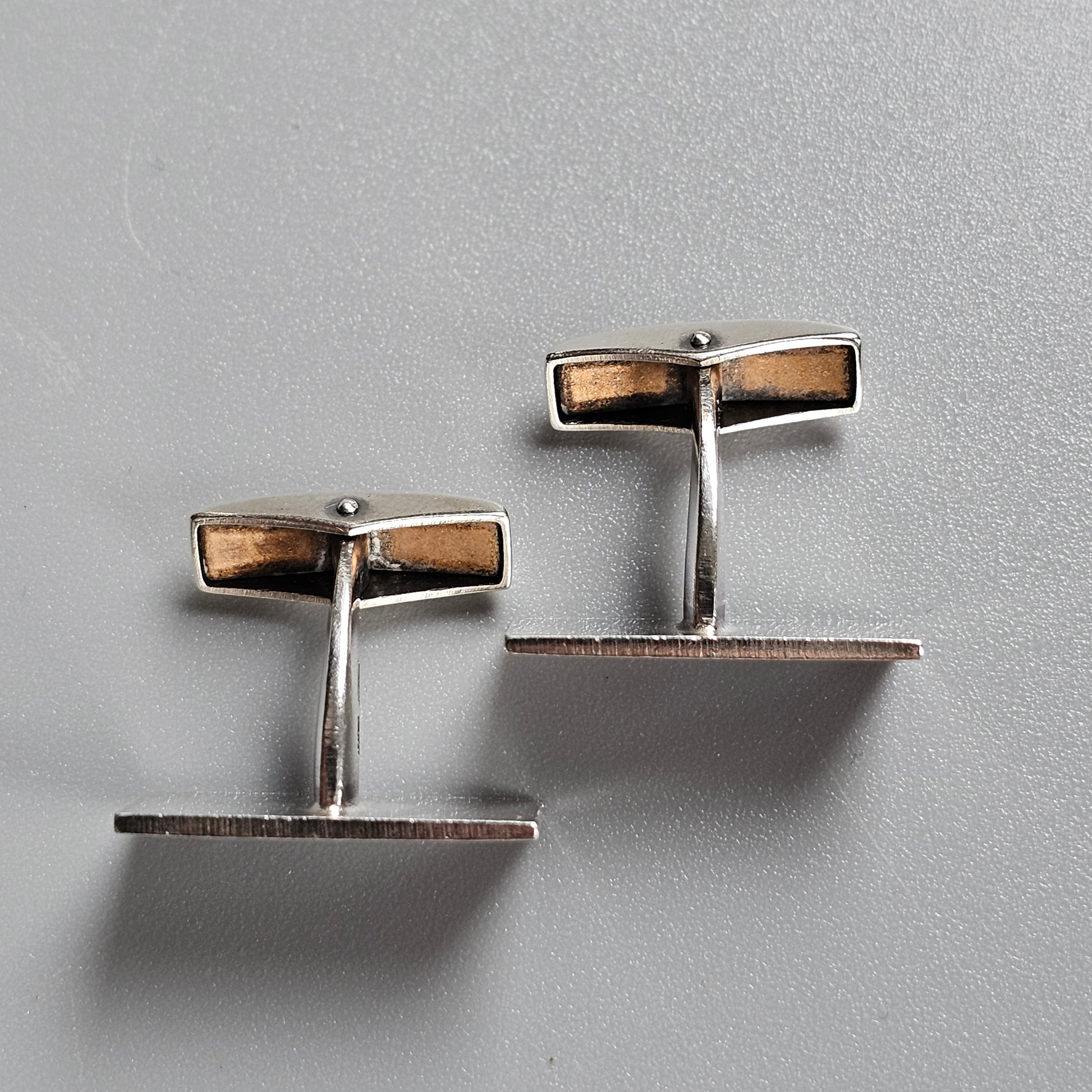 Pair of silver cufflinks with rectangular brown inlays.