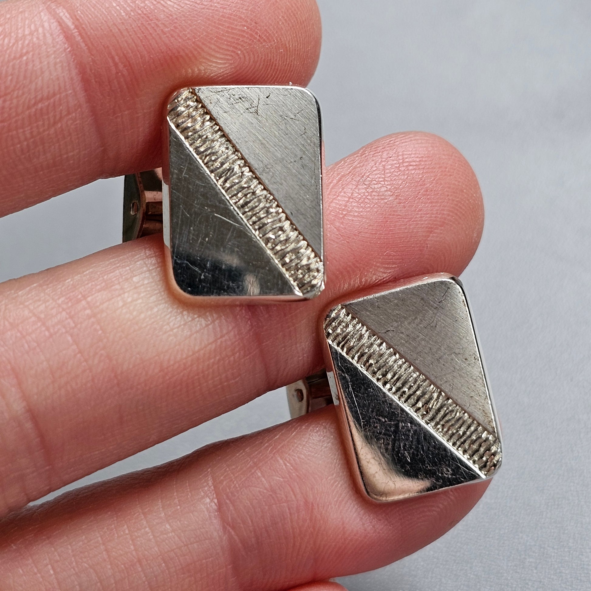 Pair of silver cufflinks with diagonal textured stripes.