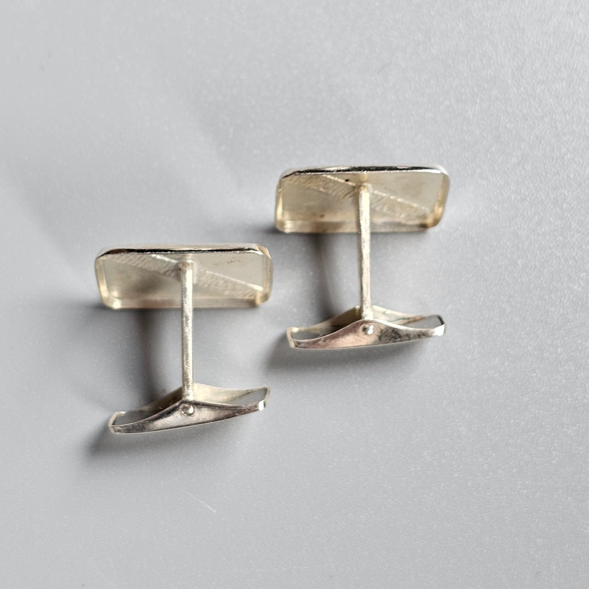 Pair of rectangular silver cufflinks with a simple, modern design.