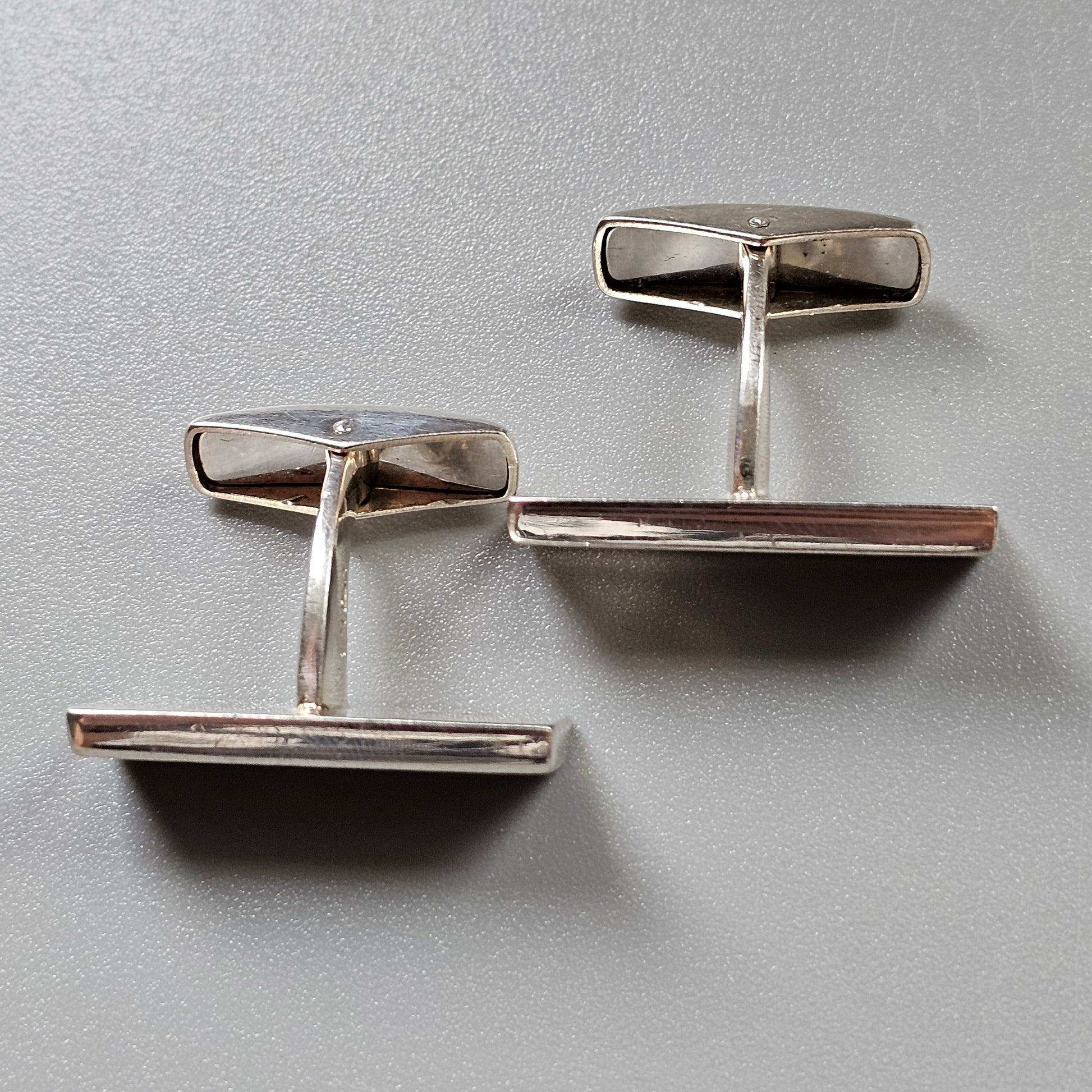 Pair of silver cufflinks with rectangular faces.