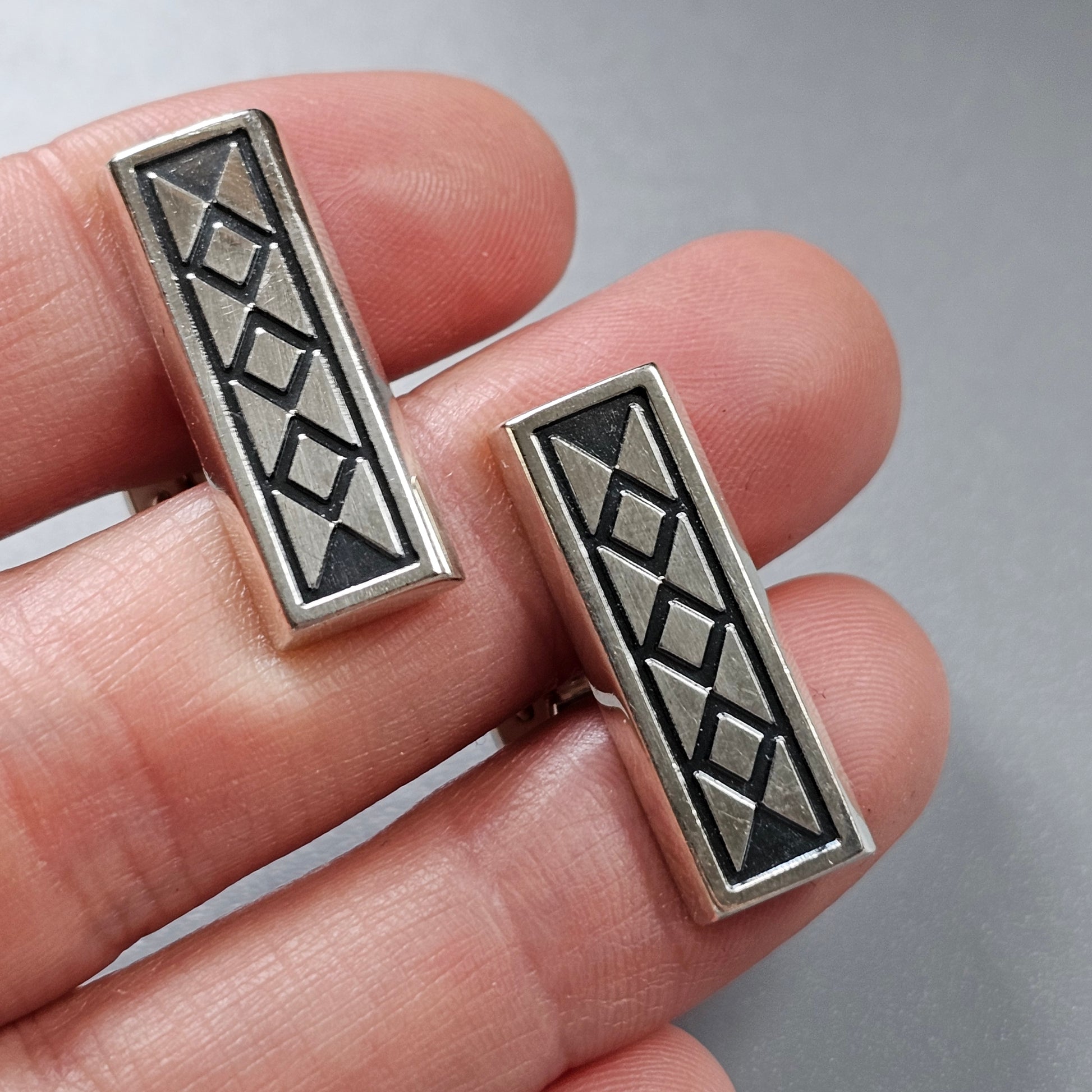 Silver rectangular earrings with a geometric diamond pattern.