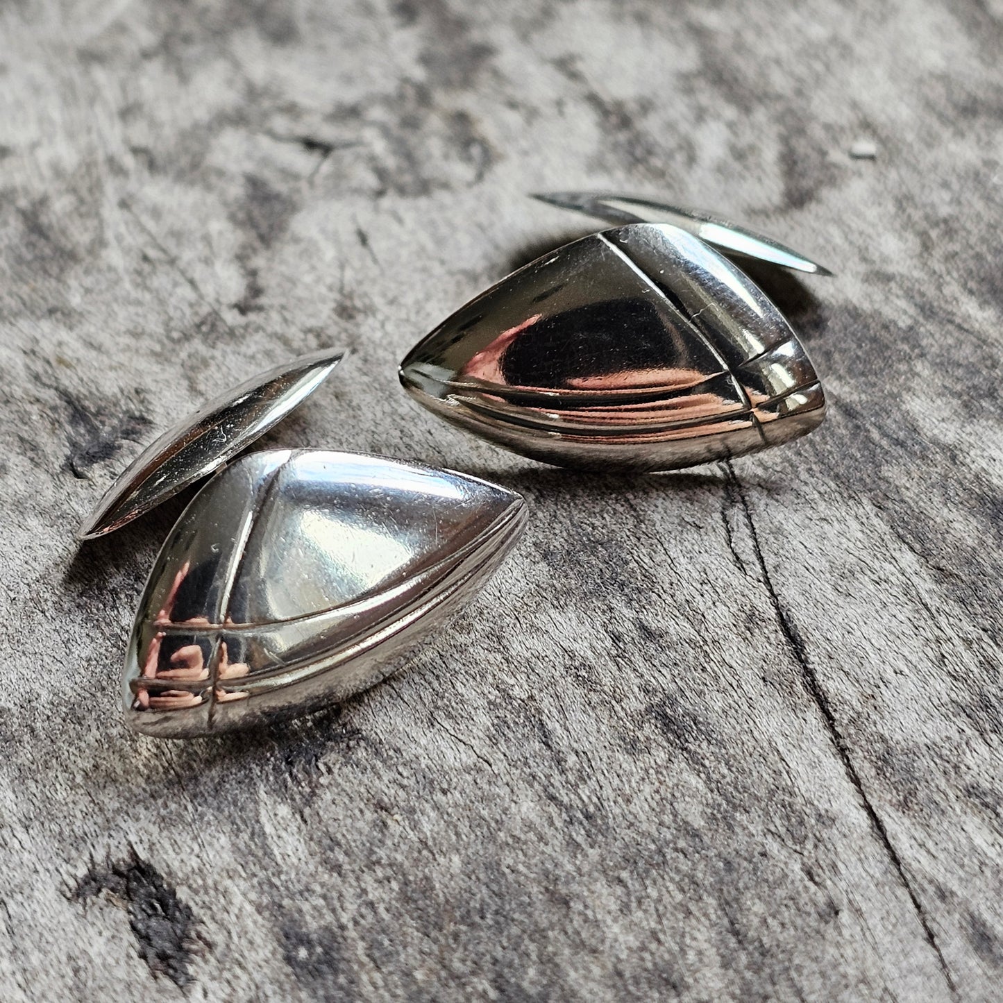 Pair of sleek, metallic earrings with a teardrop shape and rose gold accents.