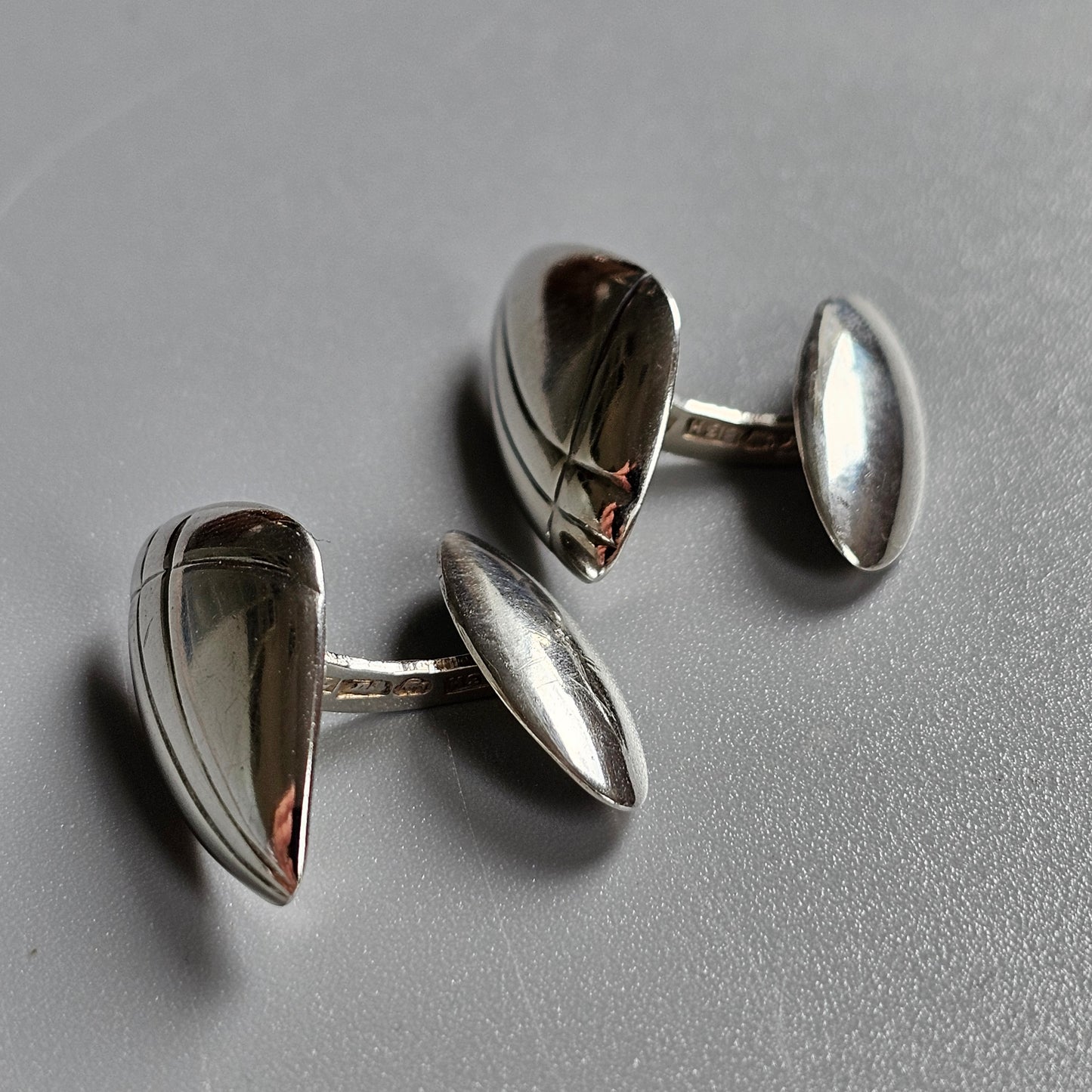 Pair of silver teardrop-shaped cufflinks with oval backs.