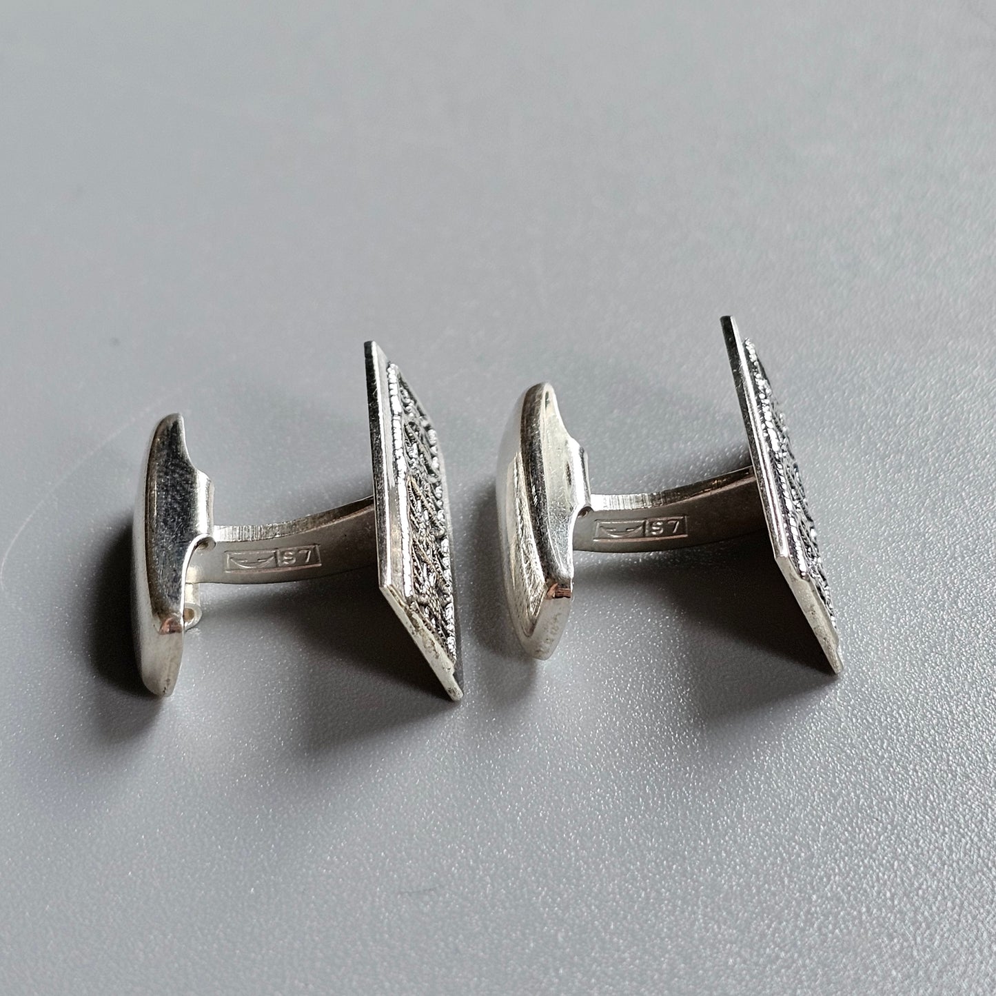 Pair of silver cufflinks with diamond-studded rectangular faces.