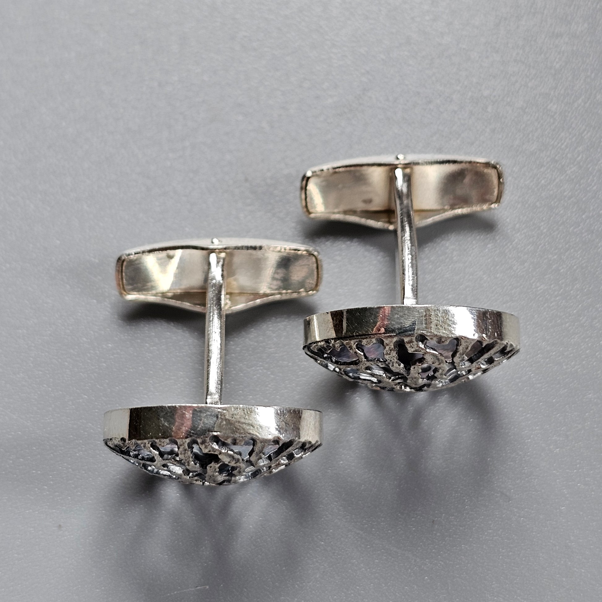 Pair of silver cufflinks with textured circular faces.