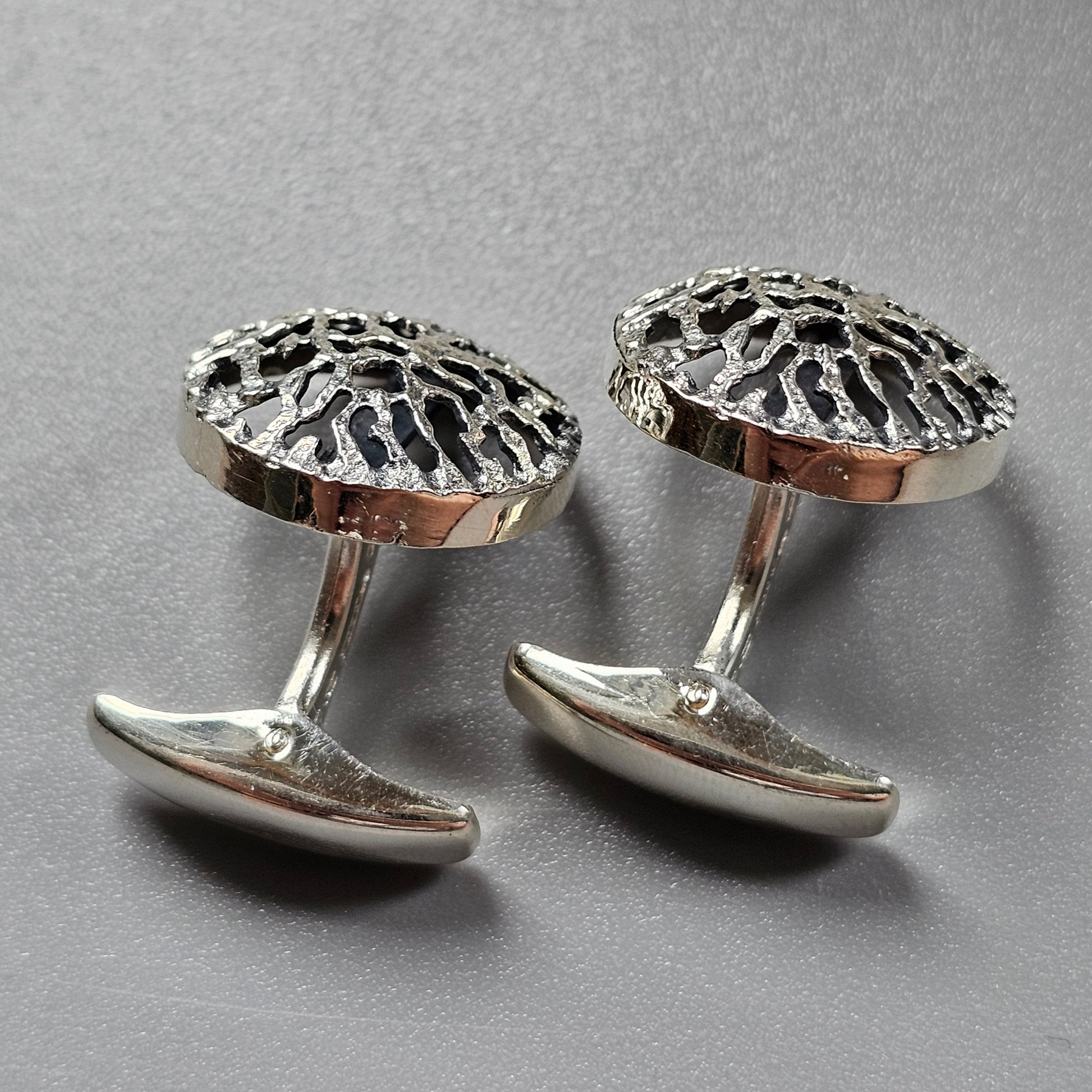 Pair of silver cufflinks with intricate openwork dome designs.