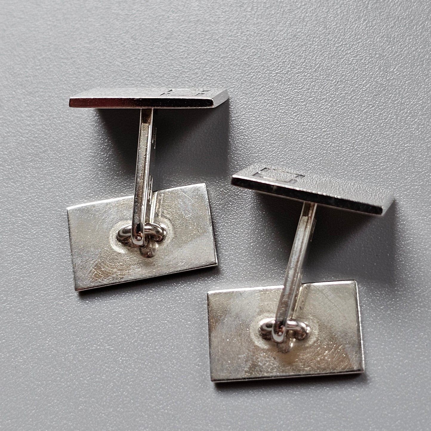 Pair of silver and brown rectangular cufflinks.