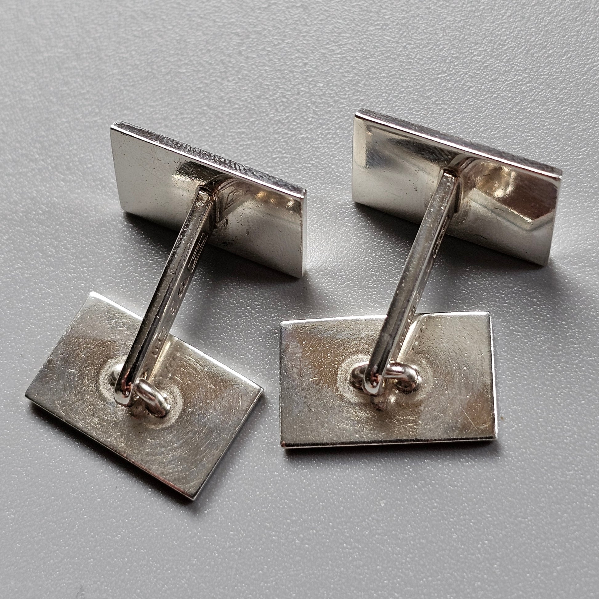 Pair of silver rectangular cufflinks with bar connectors.