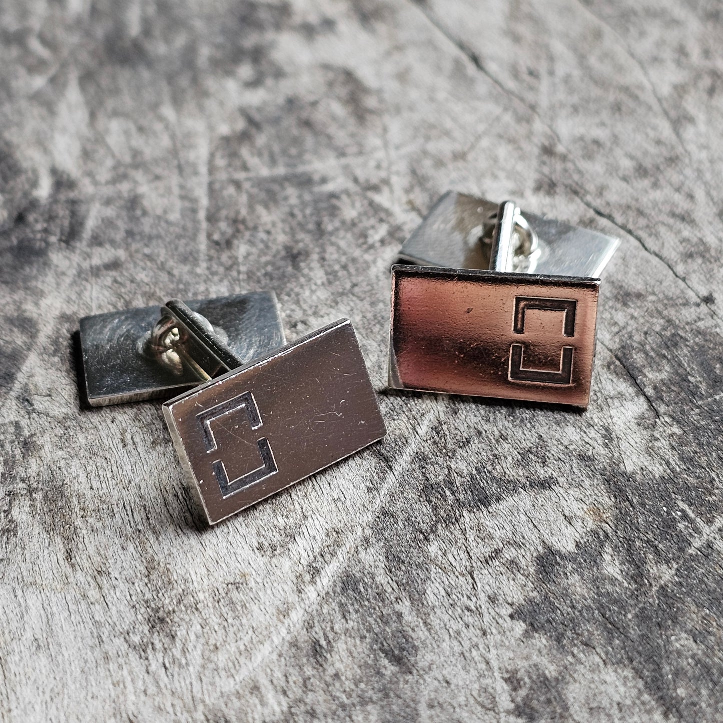 Pair of rectangular metal cufflinks with a geometric design.