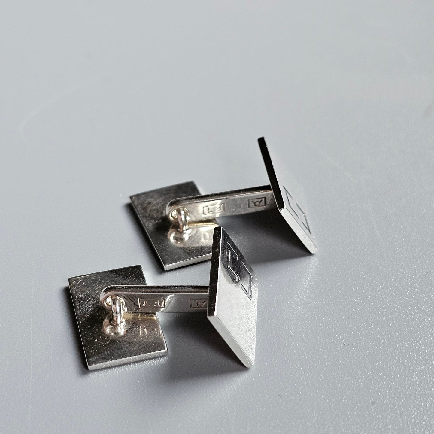 Pair of silver cufflinks with square designs.