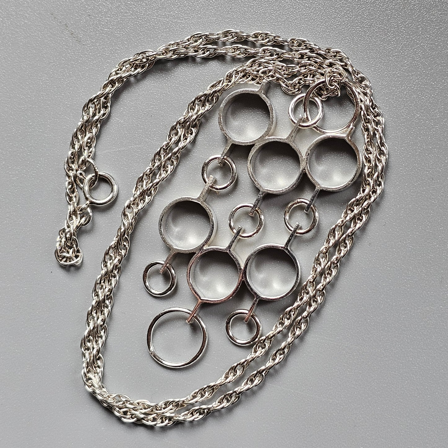 Silver necklace with multiple circular pendants of varying sizes.