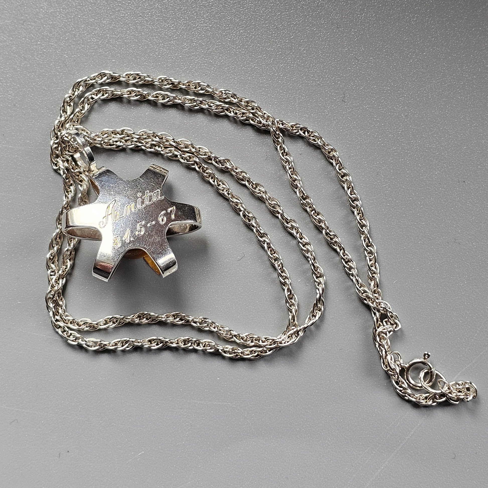 Silver puzzle piece pendant on a chain necklace.