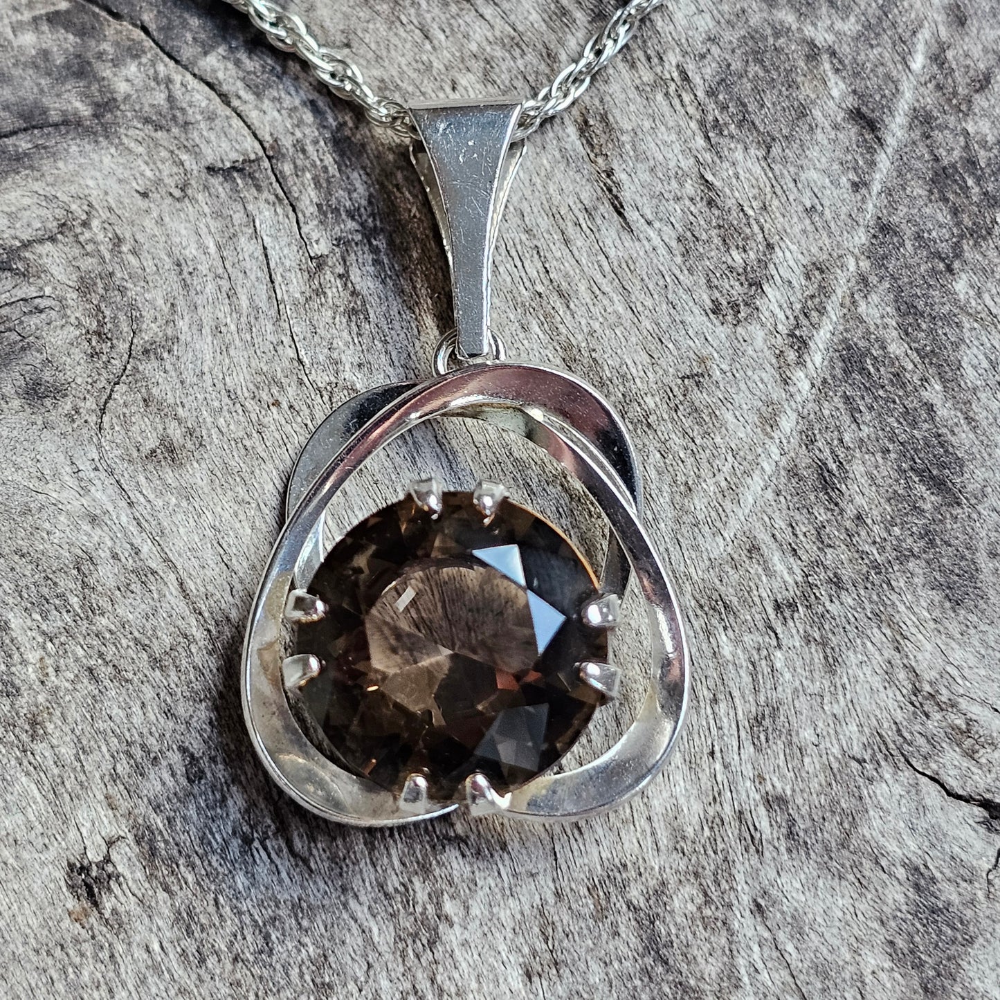 Silver pendant necklace featuring a smoky quartz gemstone set in a circular design.