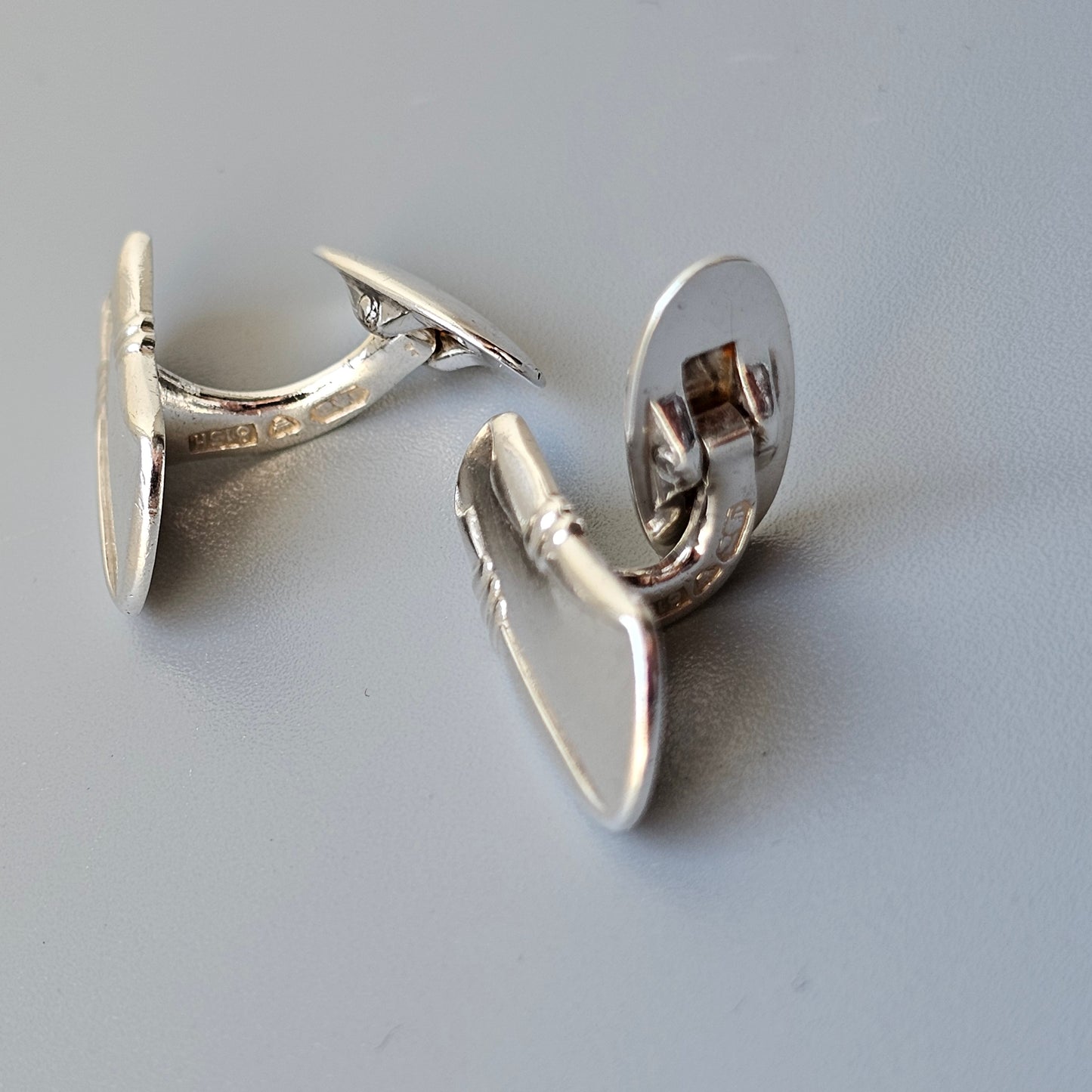 Pair of silver cufflinks with curved, organic shapes.