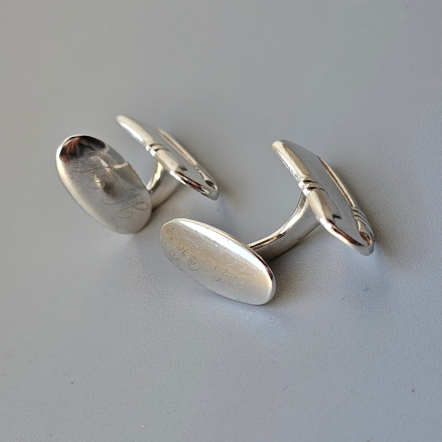 Pair of silver oval cufflinks with swivel bar fasteners.