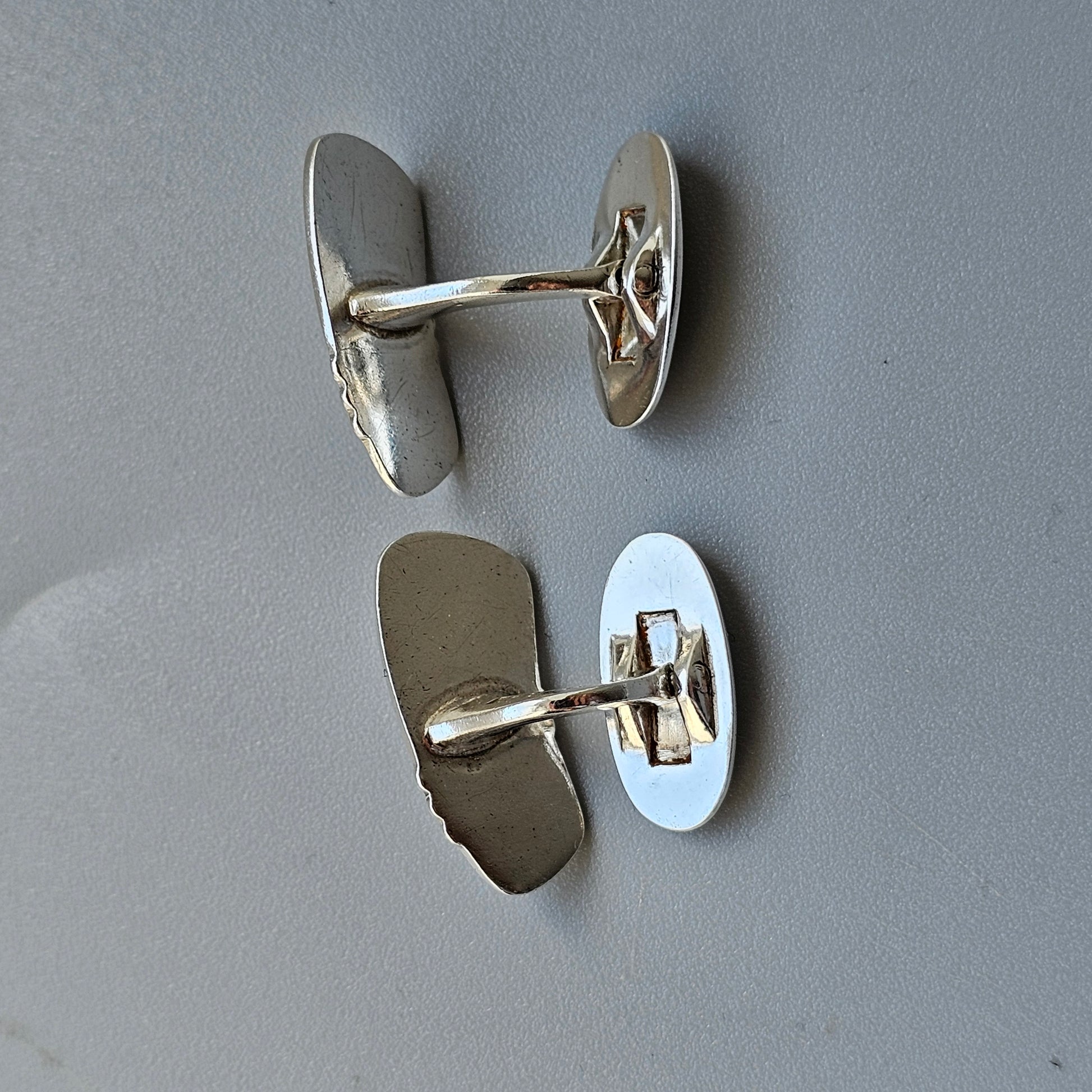 Pair of silver cufflinks with oval-shaped faces.