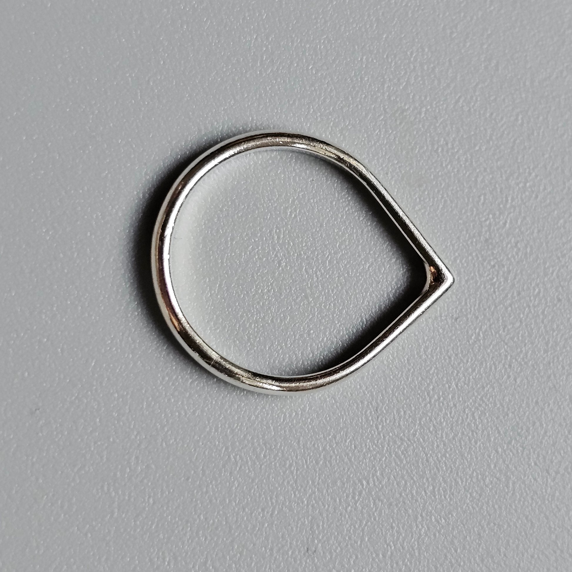 Teardrop-shaped silver ring or loop with a pointed end.