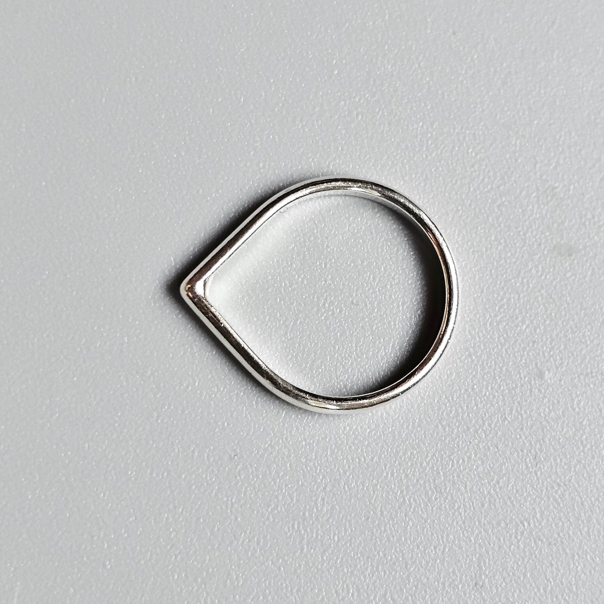 Teardrop-shaped silver ring or loop.