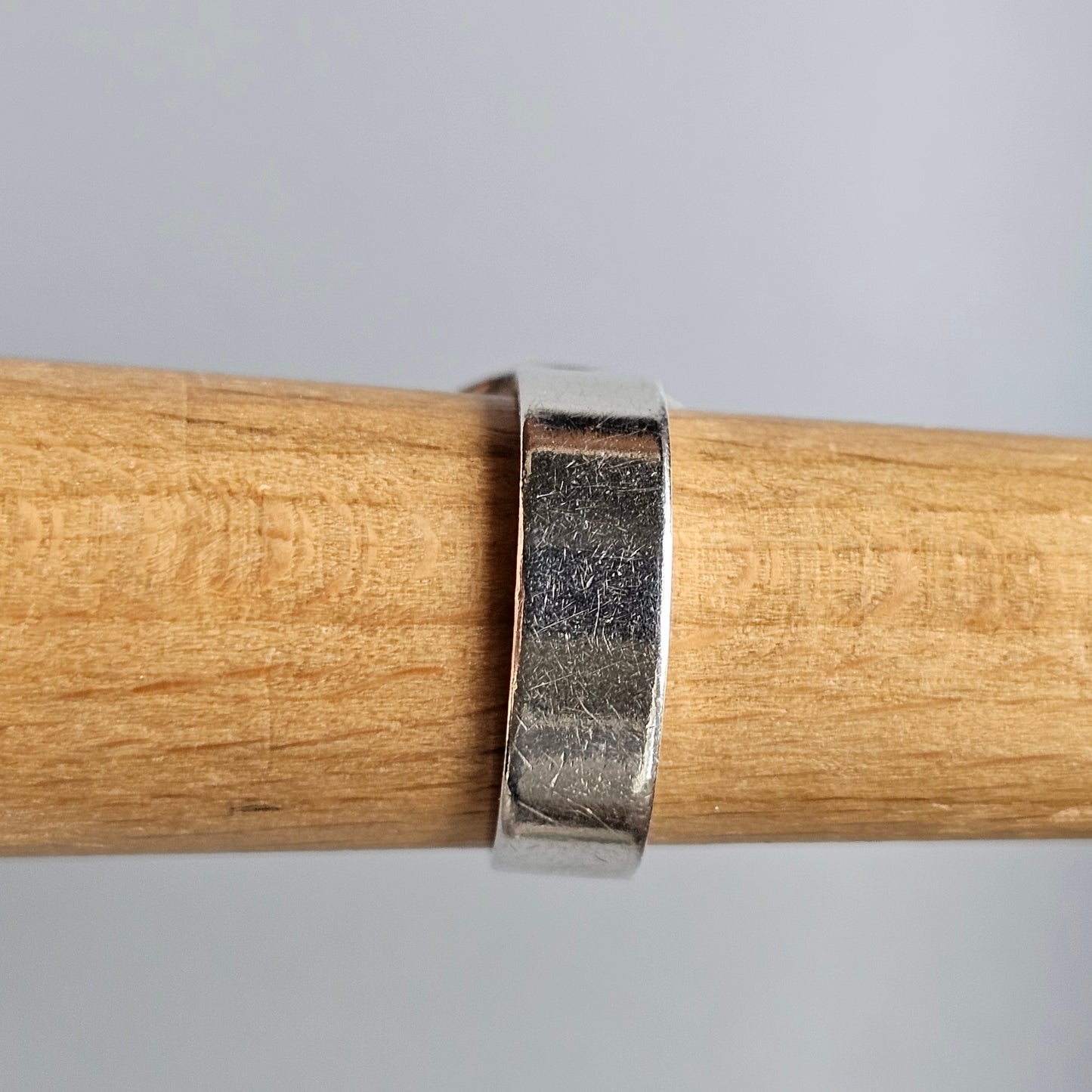 Wooden handle or tool shaft with a metal band wrapped around it.