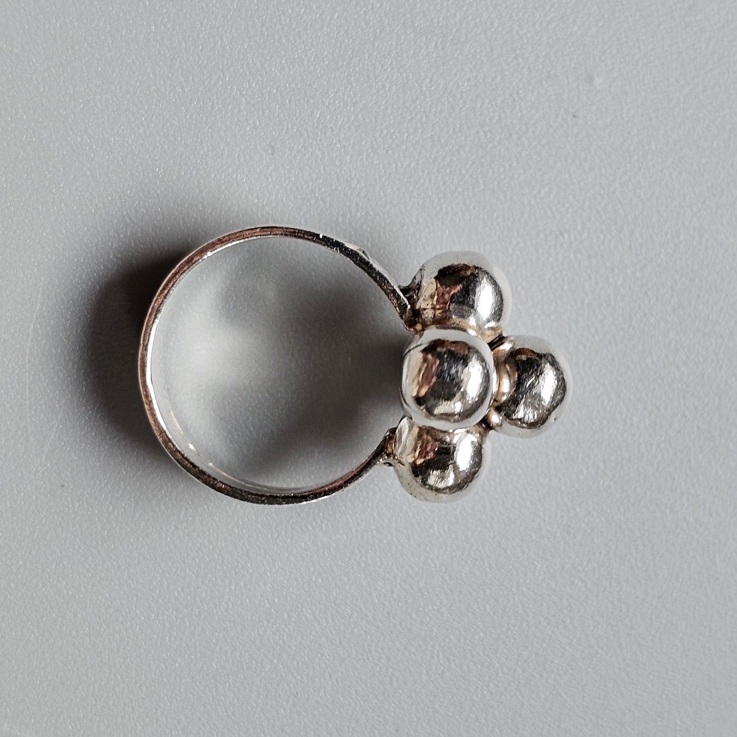 Silver ring with a flower-shaped design on top.