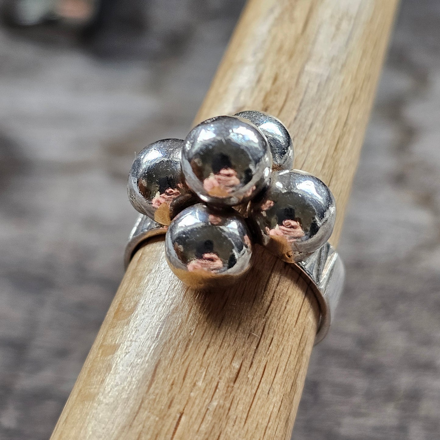 Silver ring with four spherical beads arranged in a clover-like pattern.