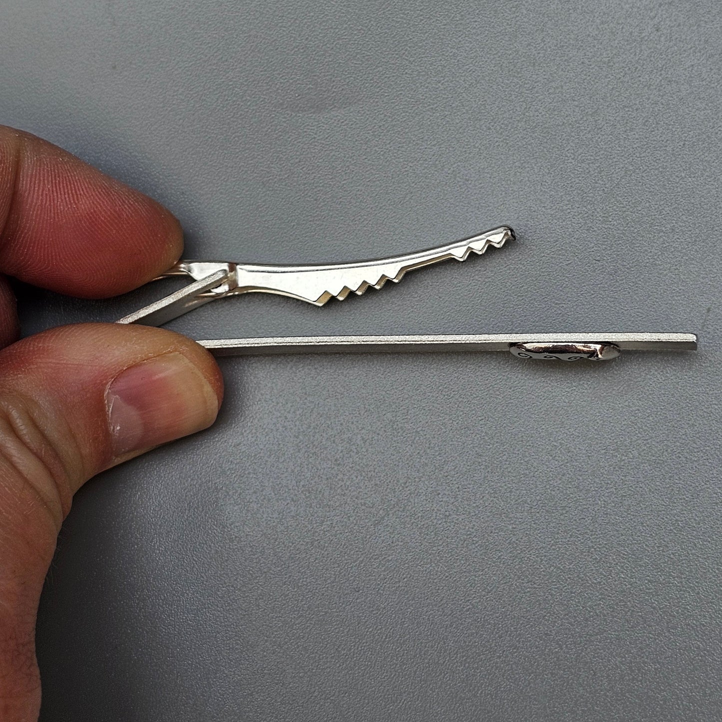 Lockpicking tool or tension wrench held between fingers.