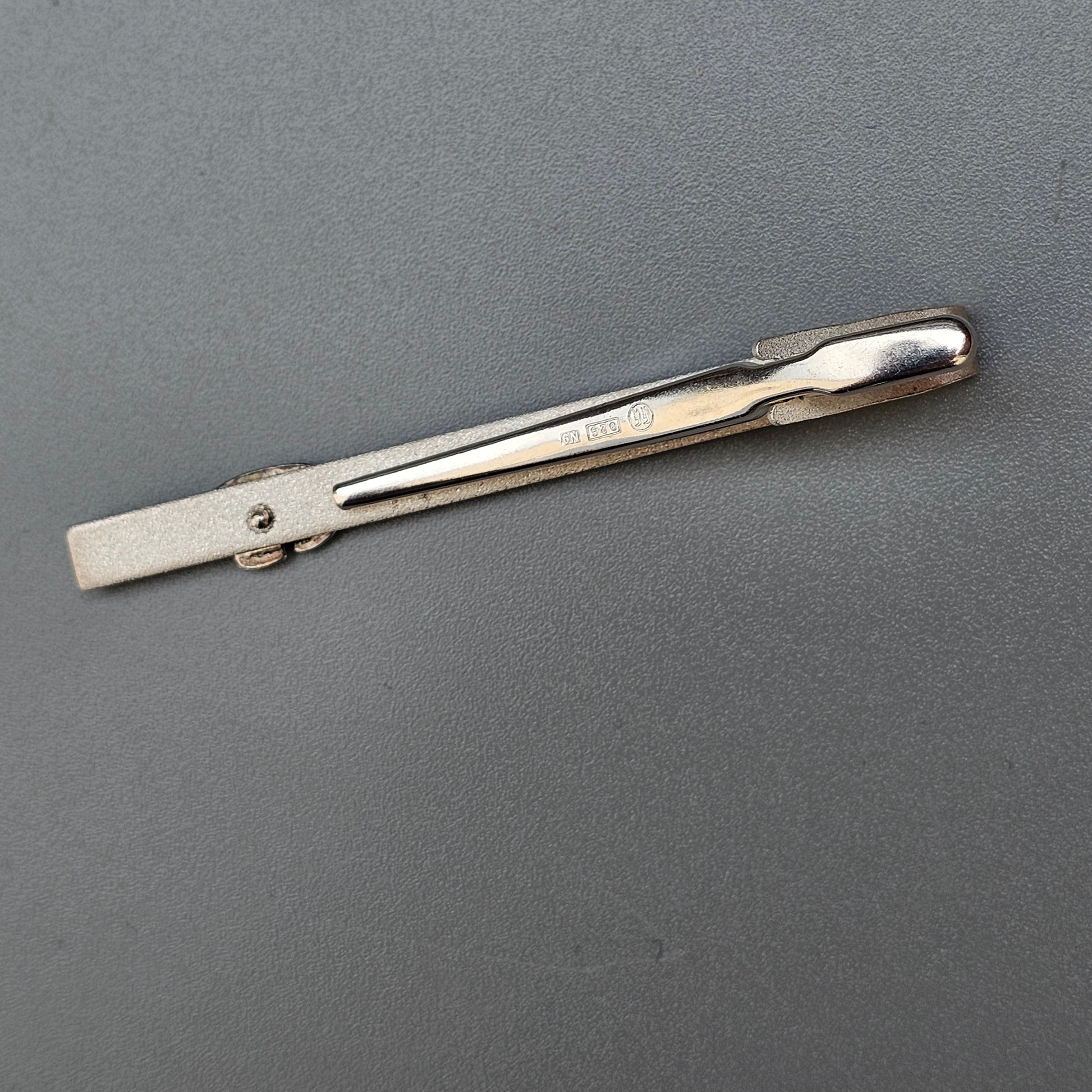 Metal hair clip or barrette with a spring-loaded mechanism.