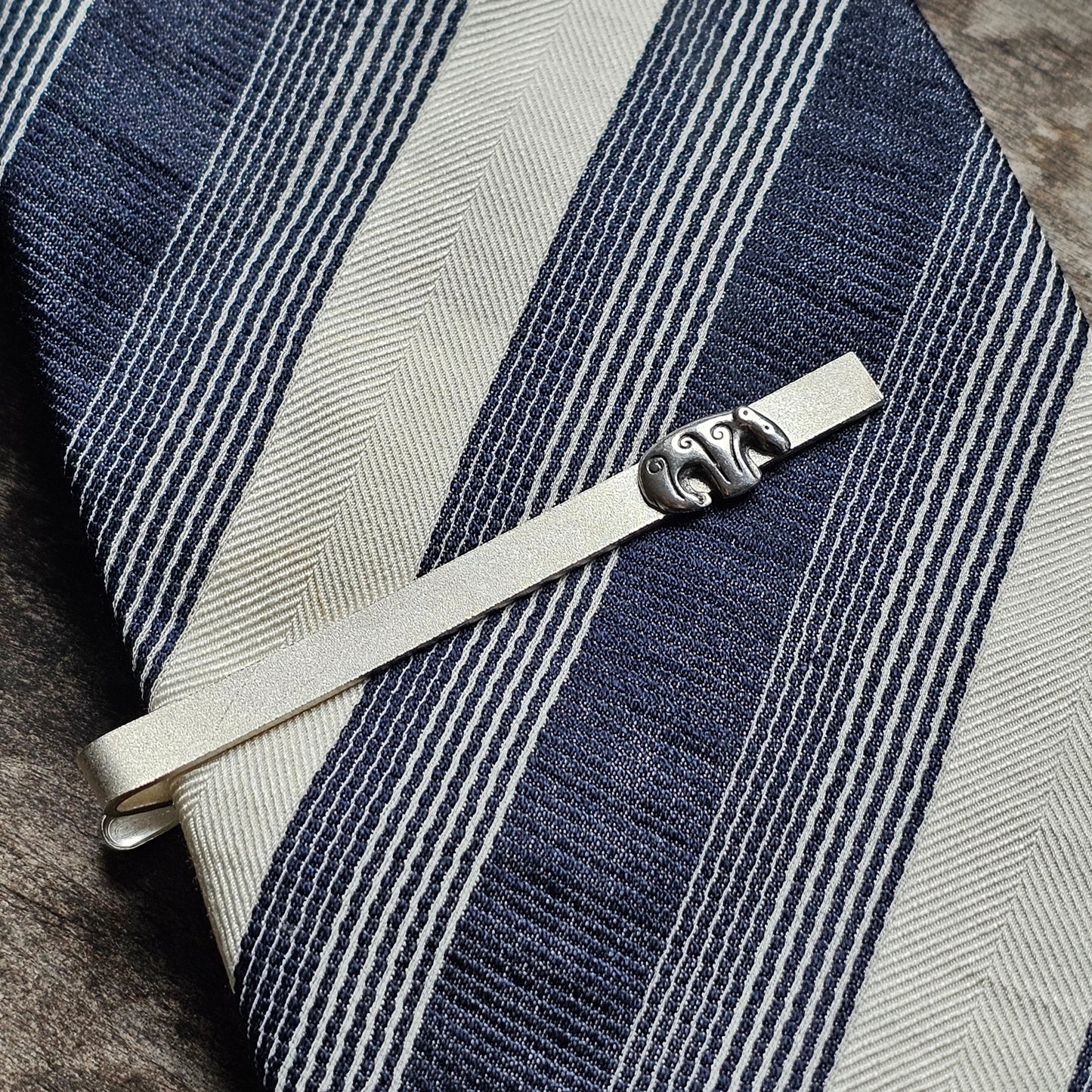 Striped blue and white necktie with a silver tie clip.