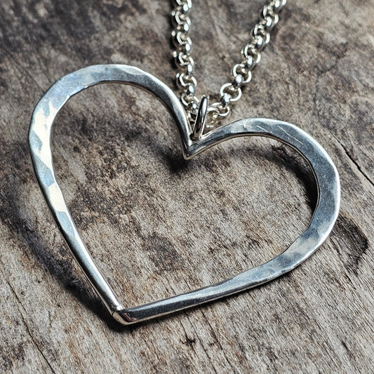 Silver heart-shaped pendant necklace on a chain.