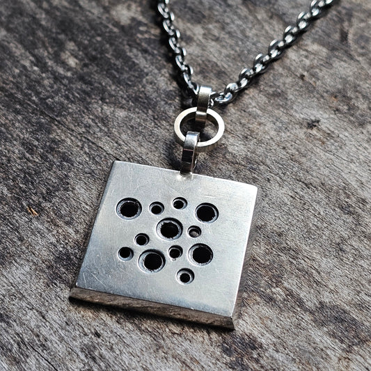 Silver square pendant necklace with multiple circular holes in a scattered pattern.