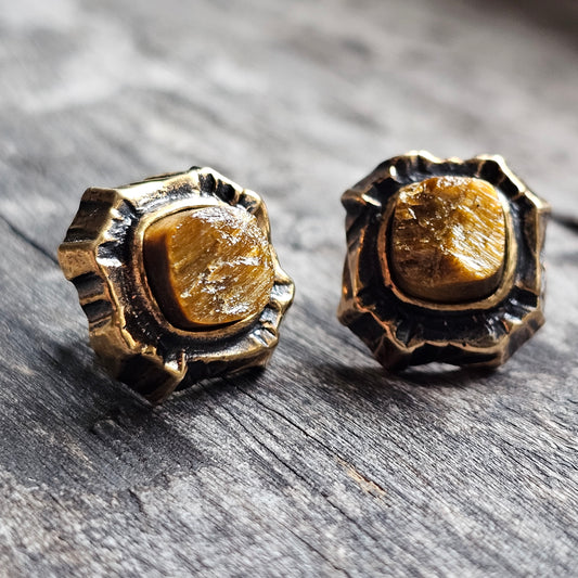 Pair of ornate gold stud earrings with rough-cut gemstones.