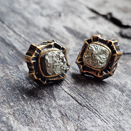 Pair of antique-style gold earrings with rough, textured silver-colored centers.