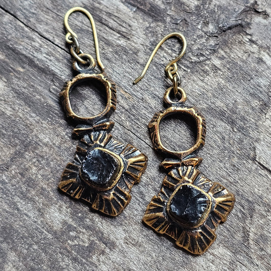 Pair of ornate brass and dark stone dangle earrings.