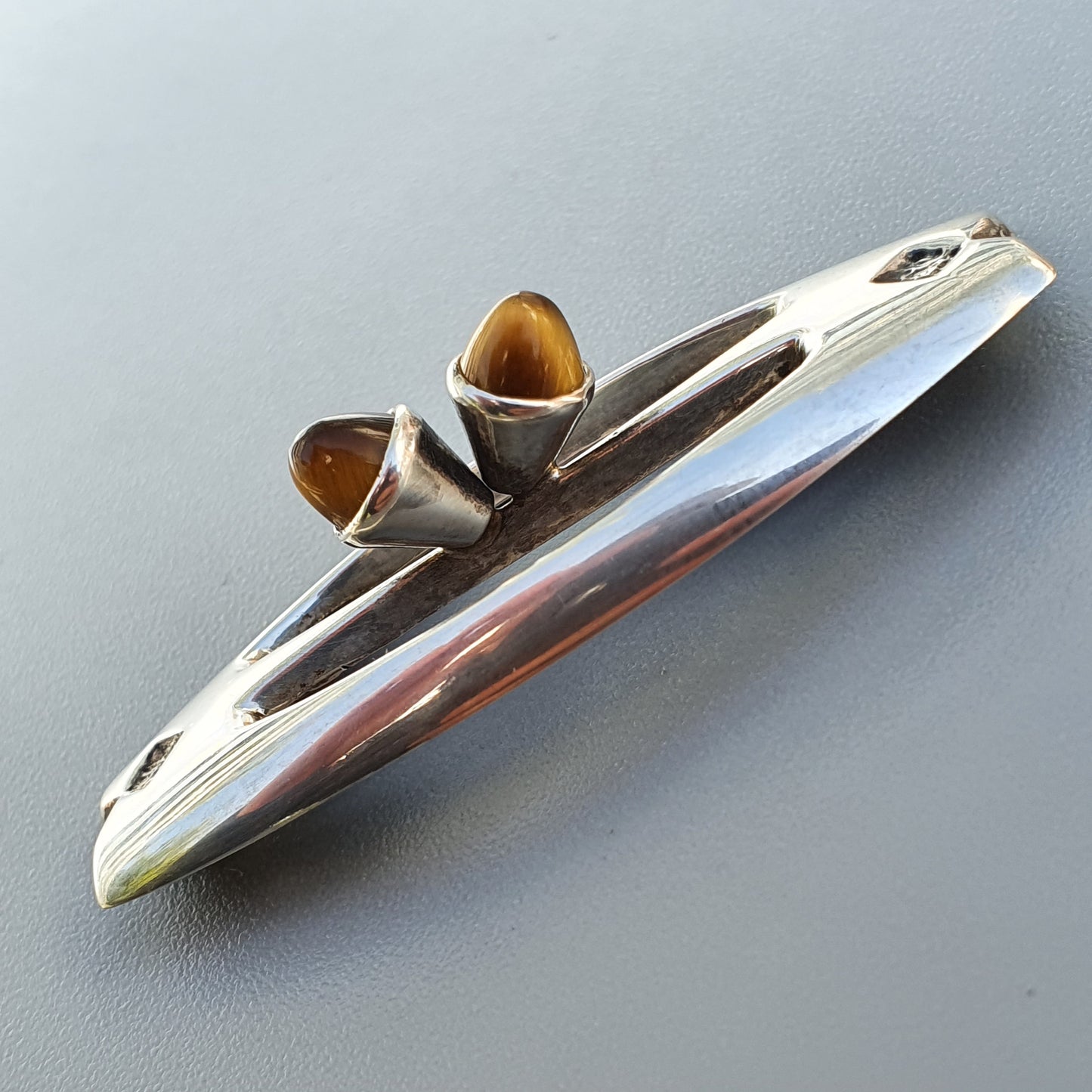 Sleek, futuristic-looking metal kazoo with a streamlined design.